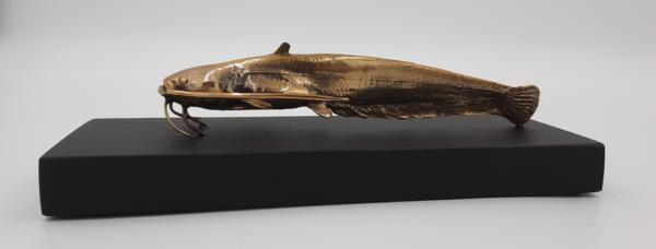 амас-1.png Handmade Bronze catfish sculpture on a wooden table.